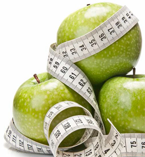 Tape measure around a pile of green apples