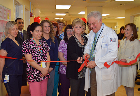 Dr. Andrew Cohen cuts the ribbon on the new dialysis facility with members of the Dialysis Unit and other Providence VAMC staff looking on.